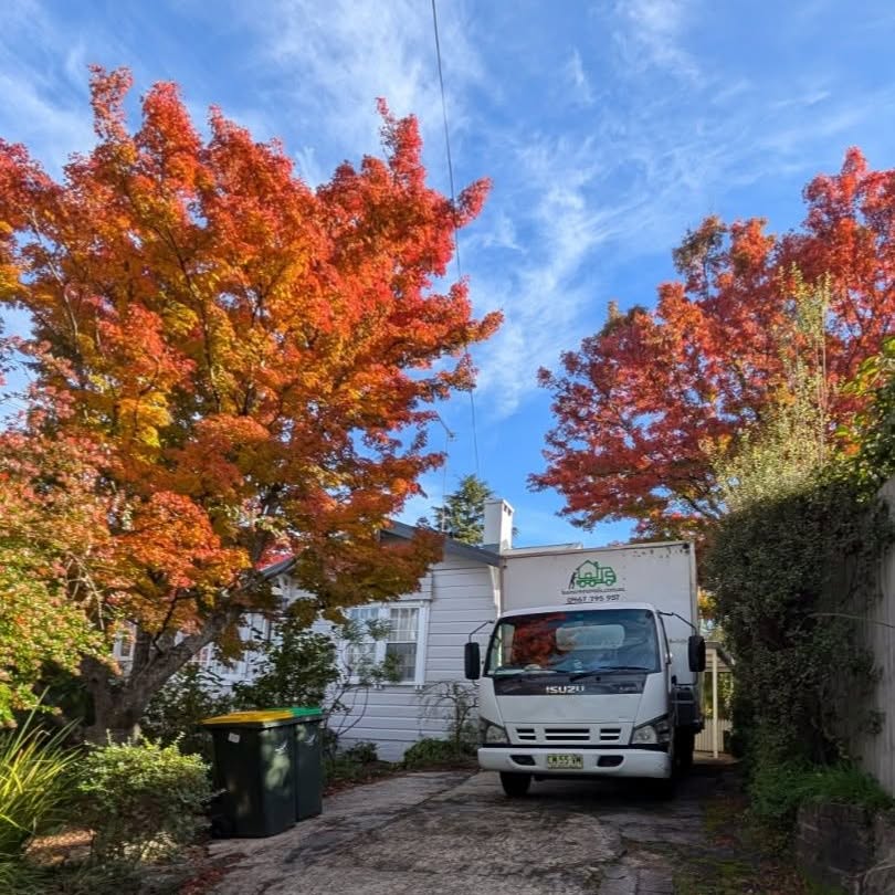 A Bons Removals truck in a Blue Mountains driveway under red and orange autumn trees