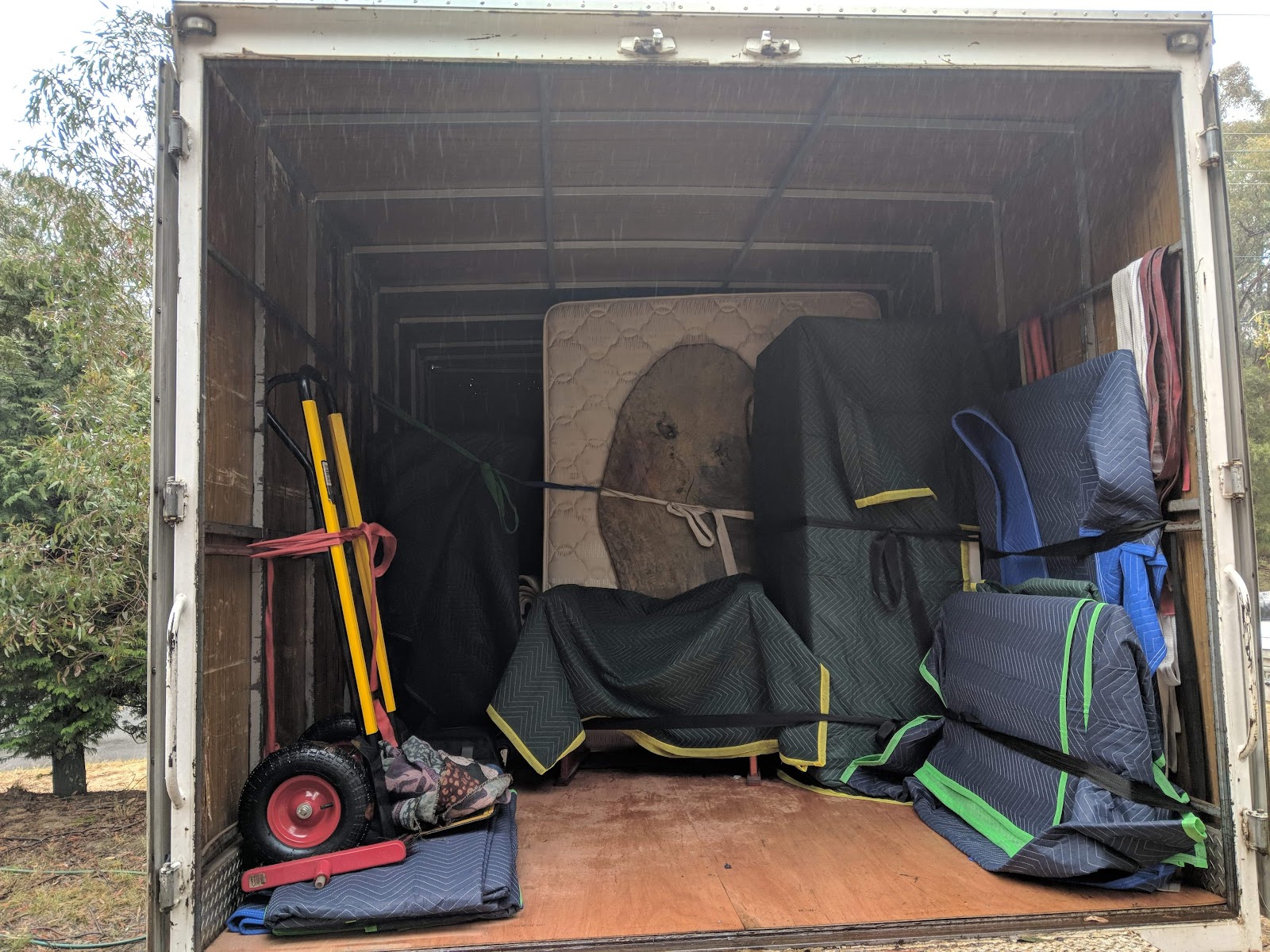 Inside a Bons Removals truck: trolleys, moving blankets and furniture strapped in