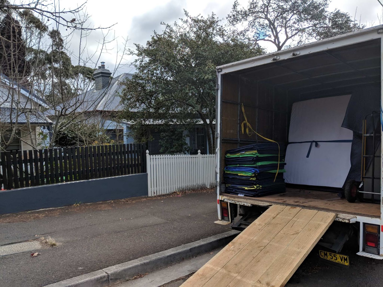 Bons Removals truck with its loading ramp down outside a weatherboard house