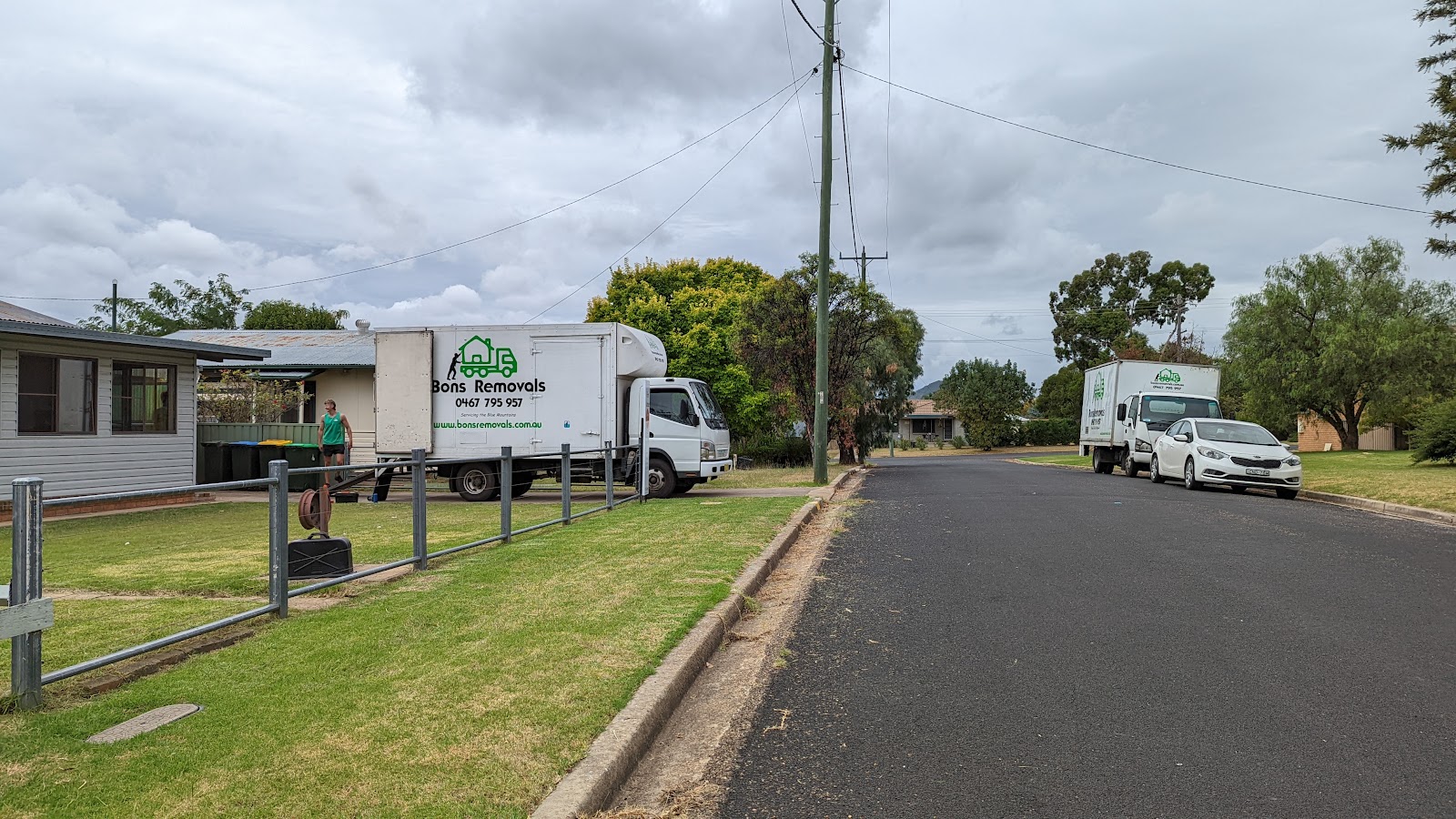 Two Bons Removals trucks on a quiet residential street